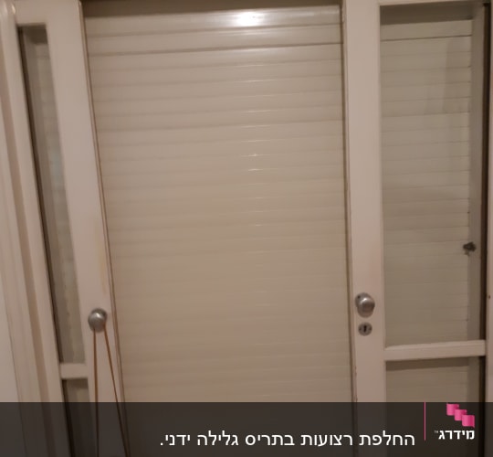 תריסים סגורים על דלת זכוכית עם ידיות מתכת